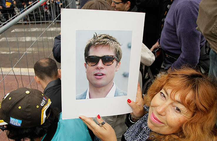 Cannes day 7: A fan holds a portrait of Brad Pitt for him to sign