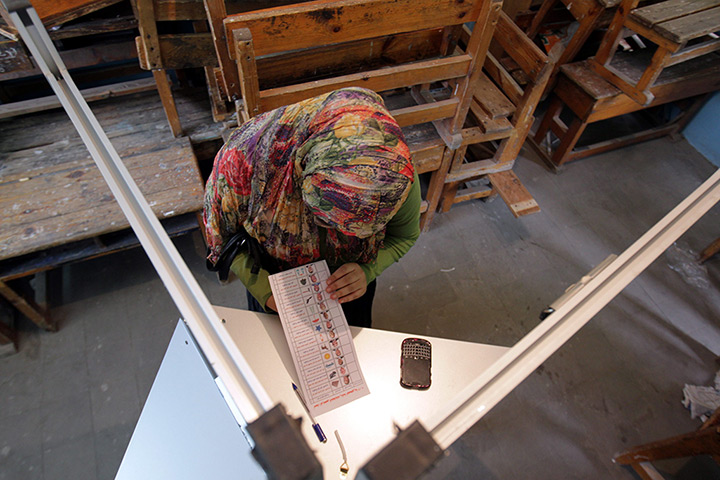 Egypt elections: An Egyptian woman looks at her ballot before filling during the vote