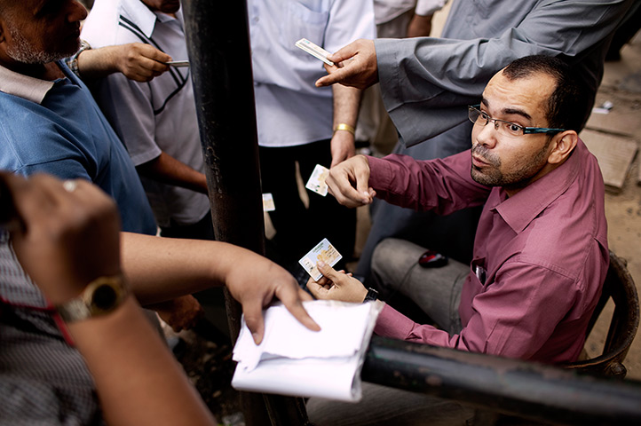 Egypt elections: An independent volunteer helps voters to locate a polling centre in Maadi