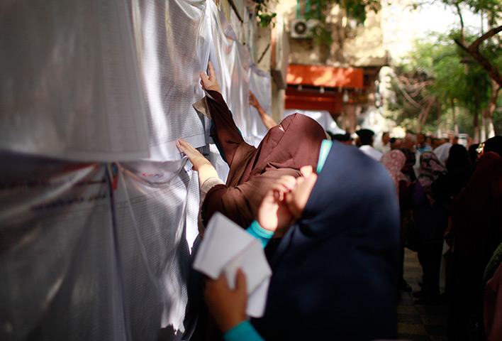 Egypt elections: Voters search for their names outside a polling station in Cairo