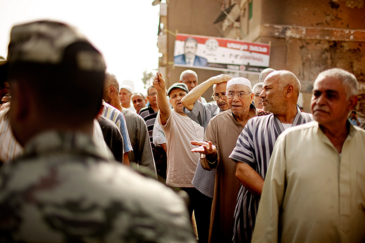 Egypt elections: Egyptian voters argue with a solider as they wait cast ballots in Basateen