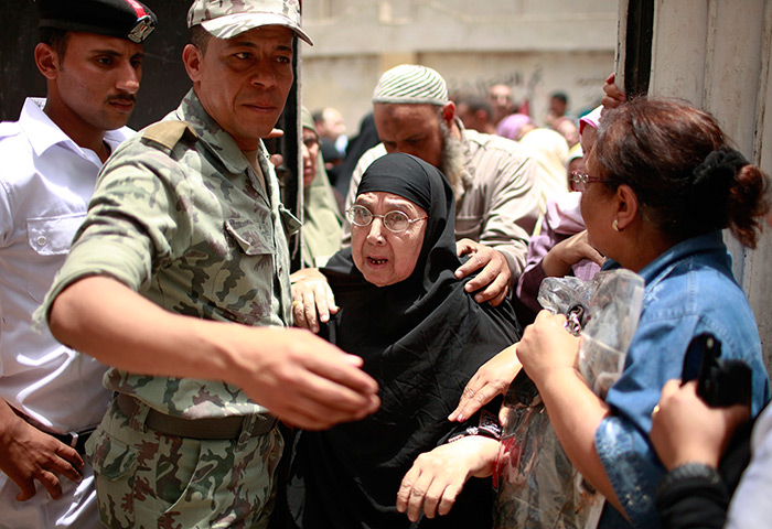 Egypt elections: A woman is assisted outside a polling station