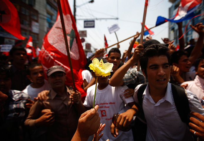 24 hours: Kathmandu, Nepal: A student holds out a flower during a protest rally 