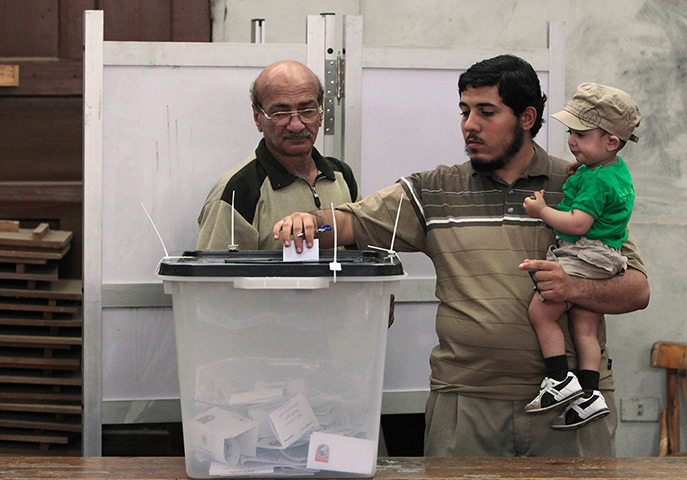 Egypt election: A man casts his vote at a polling station with his son