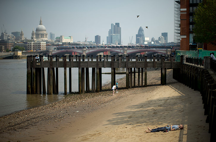 Picture desk live: A man soaks up the sun on the south bank of the River Thames
