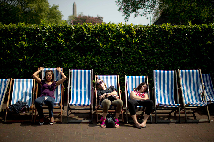 UK heatwave: Women soak up the sun on deck chairs near Embankment station