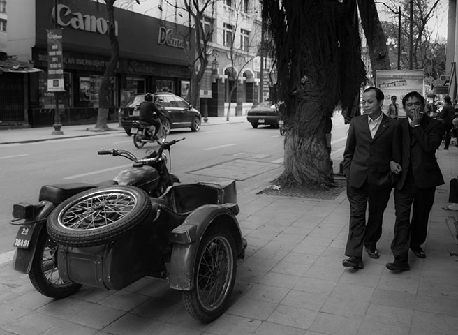 Readers' street pictures : Two men pass a motorbike