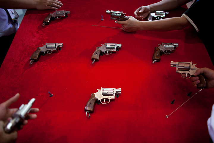 24 hours in pictures: Visitors check revolvers at a police equipment exhibition , Beijing