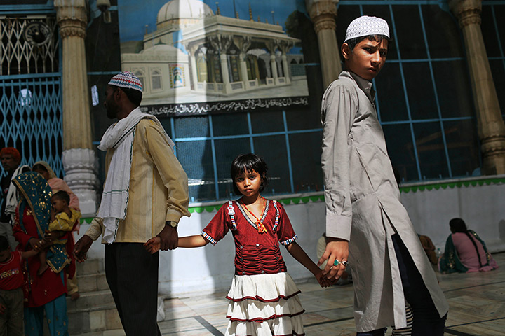 24 hours in pictures: Indian Sufi Muslim devotees walk together while visiting the Ajmer Sharif