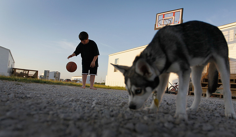 FTA: Joe Raedle: A boy plays basketball outside his family's FEMA trailer