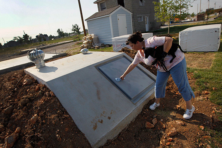 FTA: Joe Raedle: A woman shows off her newly built tornado shelter behind her home