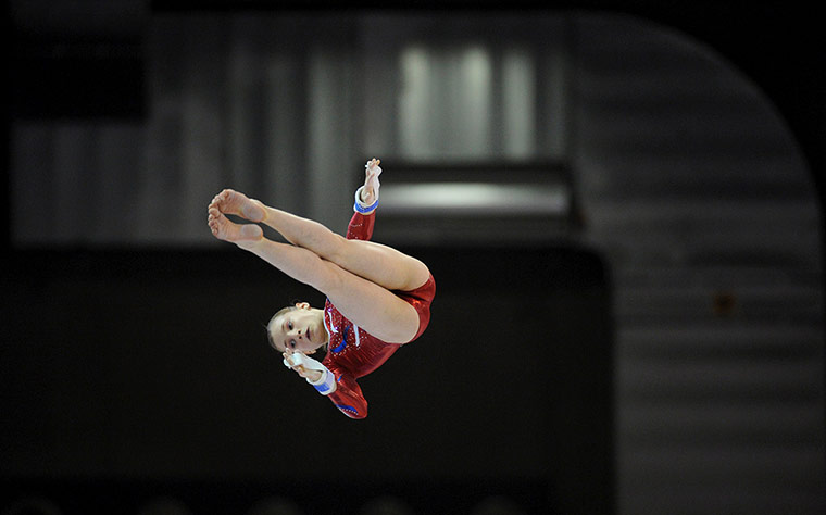 Longer View: France's Anne Kuhm performs on the uneven bars 