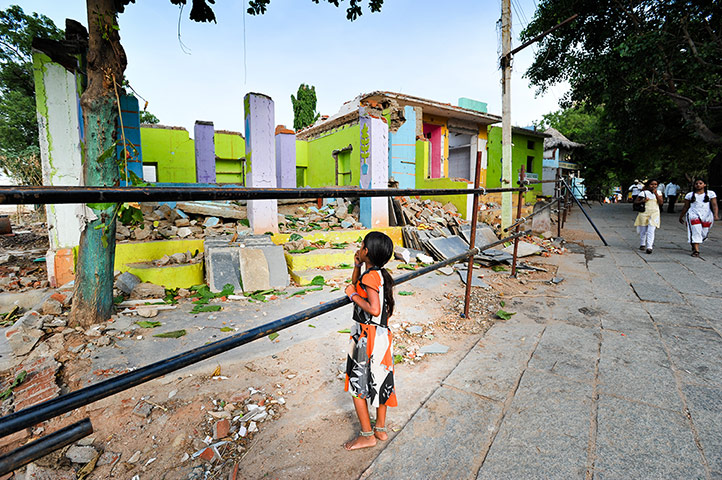 Hampi: A girl looks at the remains of homes and businesses near the Hampi bazaar