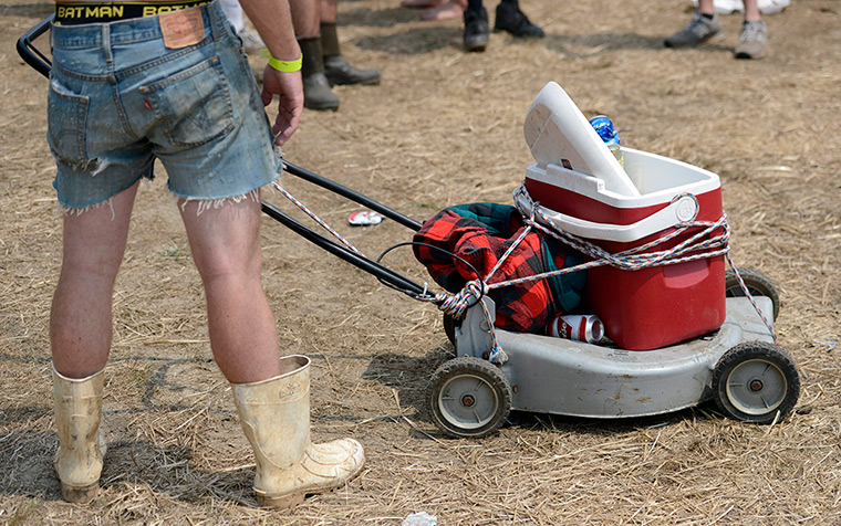 Redneck games: A visitor uses a broken lawn mower to carry his cooler box 
