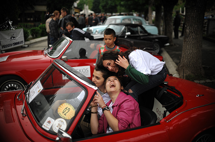 24 hours: Prizren, Kosovo: Girls sit in a vintage car on display 
