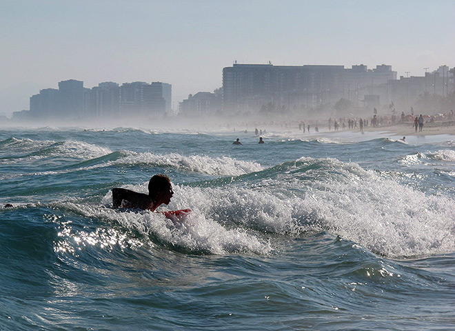 24 hours: Rio de Janeiro, Brazil: A surfer in the sea at Barra Tijuca beach