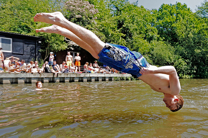 24 hours: London, England: A man dives into a pond on Hampstead Heath