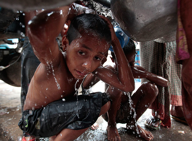 Picture Desk Live: Child takes shower in water leaking from lorry 