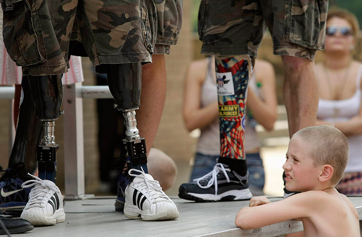 Picture Desk Live: A child looks at the prosthetic legs of Wounded Warrior