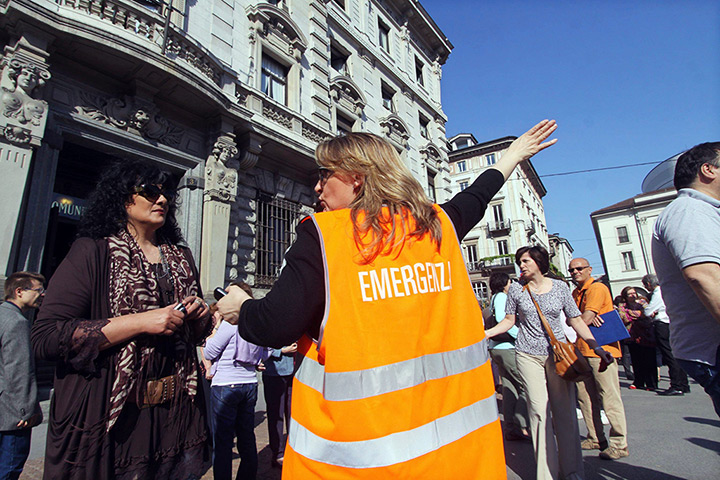 Italy earthquake: A volunteer helps people evacuate offices in central Milan