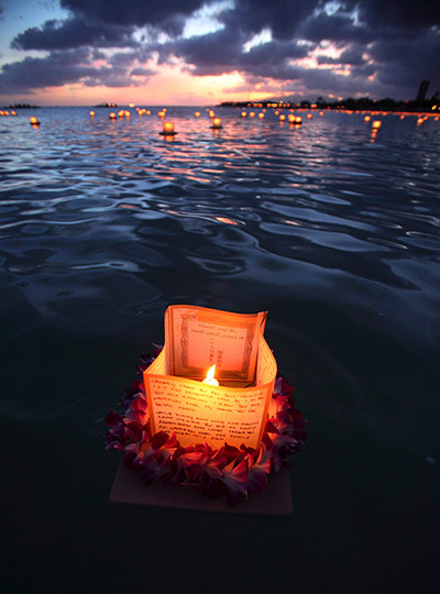 24 hours: Honolulu, Hawaii: A lantern draped with a flower lei floats on the water