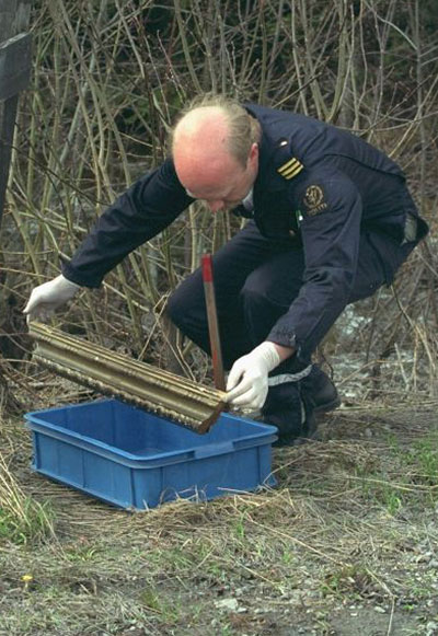 scream gallery: Part of a picture frame is recovered by a policeman