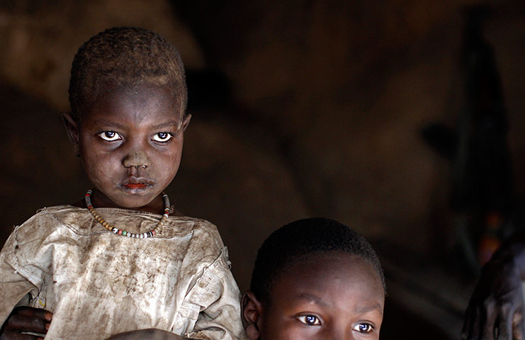 Picture Desk Live: A girl and her brother sit in a cave shelter in Tess village, Sudan