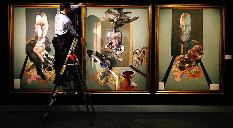 Top ten art auctions: A Sotheby's employee with Francis Bacon's Triptych, 1976