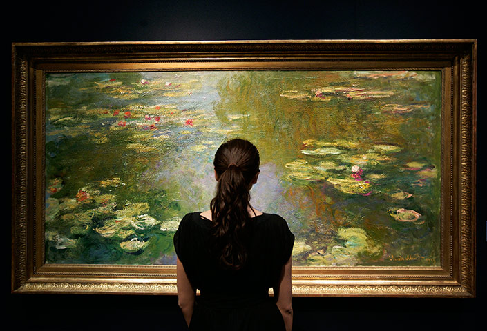Top ten art auctions: An auction house worker stands by Claude Monet's Le bassin aux Nympheas