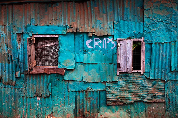 Sierra Leone Architecture: Painted metal covers the walls of a traditional Board House in Murray Town