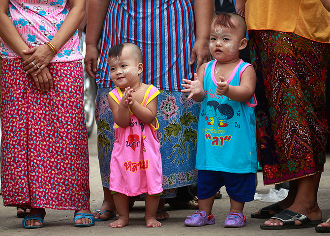 Suu Kyi visits Thailand: Burmese children clap as Aung San Suu Kyi arrives at a shrimp market 