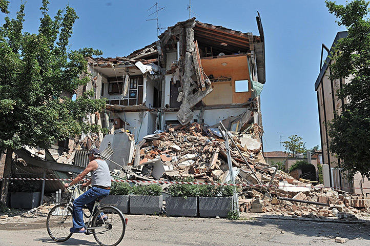 Italy earthquake: A cyclist passes by a damaged building in Rovereto, Modena district, Italy
