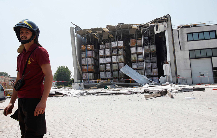 Italy earthquake: A firefighter stands next to a damaged factory in Medolle near Modena