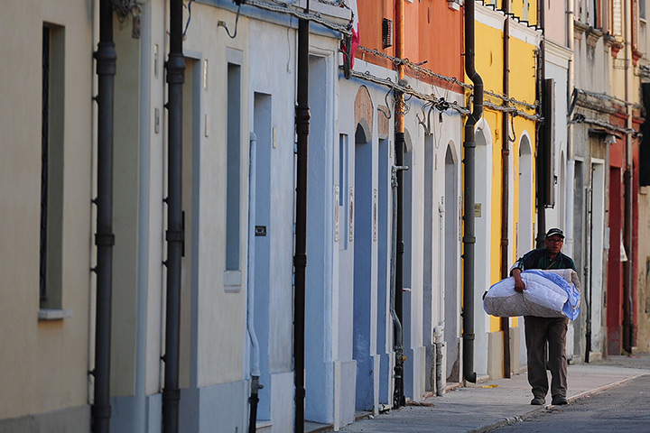 Italy earthquake: A man takes a mattress as he prepares to sleep outside, in Mirandola