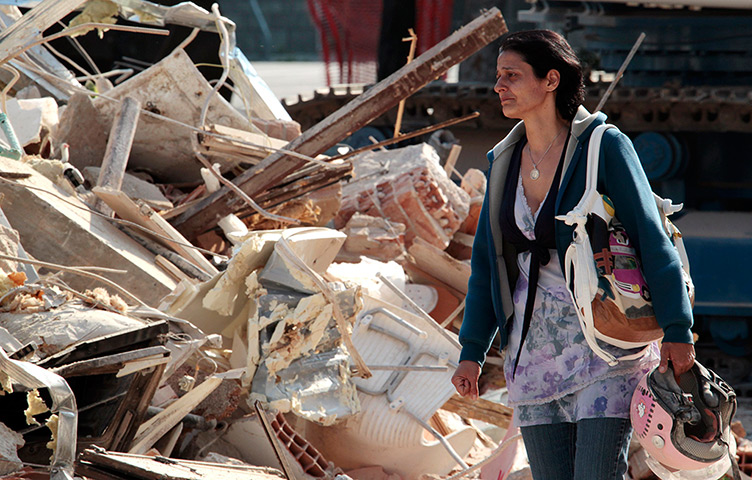 Italy earthquake: A woman cries after finding a helmet in front of a building in Cavezzo
