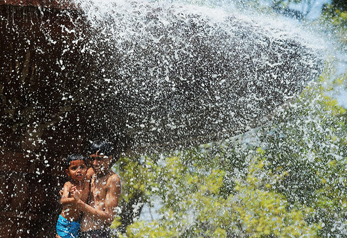 Picture Desk Live: Indian children play at a fountain near
