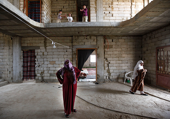 24 hours: Arssal, Lebanon: Syrian refugees stand in a house under construction