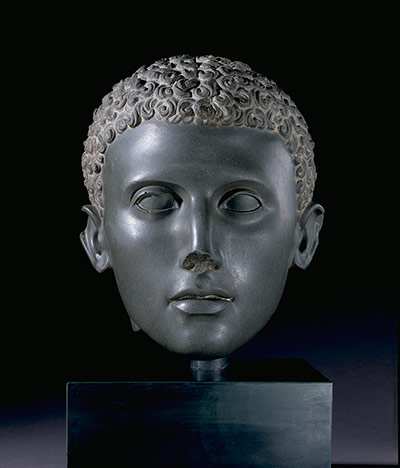 Sculpture: Head from a green siltstone statue of a young man with curly hair 100-75BC