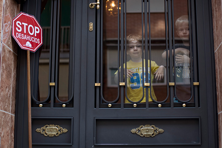 24 hours in pictures: Young boys at a entrance of a building durign stop evictions protest, Spain