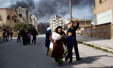 A family escapes from fighting between government troops and Free Syrian Army rebels in Idlib