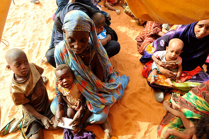 Longer View: A Malian refugee holds her baby in the M'bere refugee camp