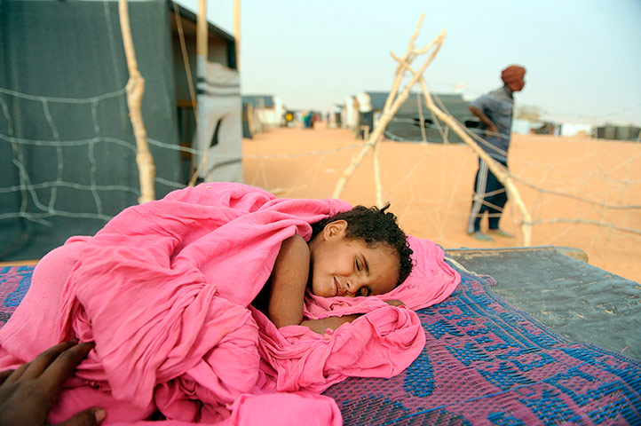 Longer View: A sick child lays on a cart as she wait to be treated