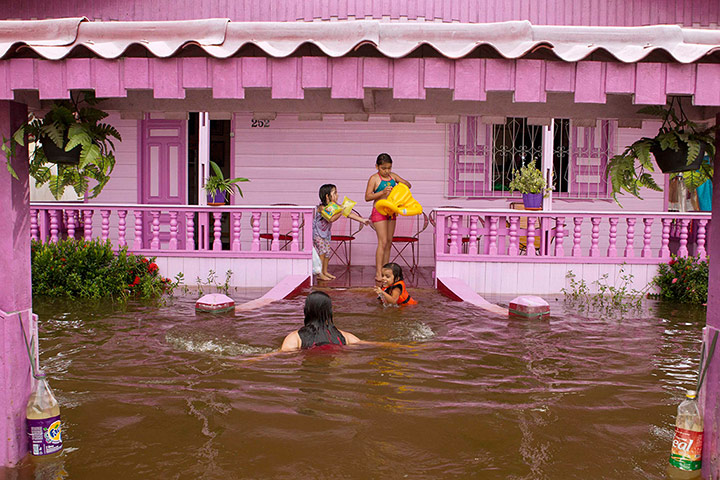 24 hours in pictures: Children stand on the porch of their flooded home