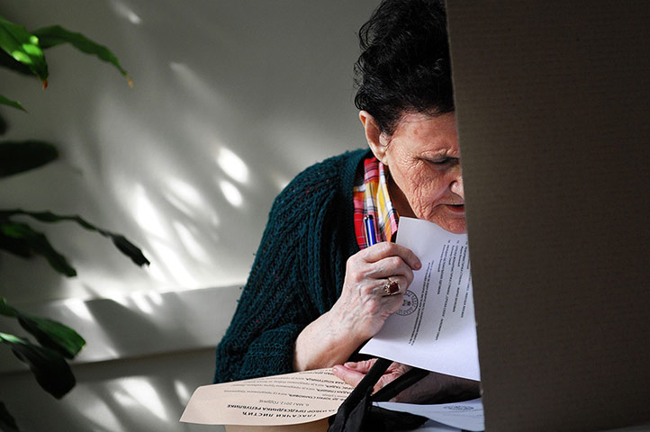Elections: A woman prepares her ballot at a polling station in Belgrade