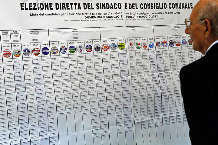 Elections: A man studies a list of election candidates at a polling station in Italy