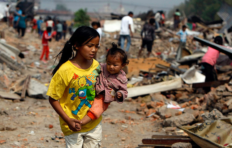 Kathmandu eviction: a Nepalese girl carries an infant