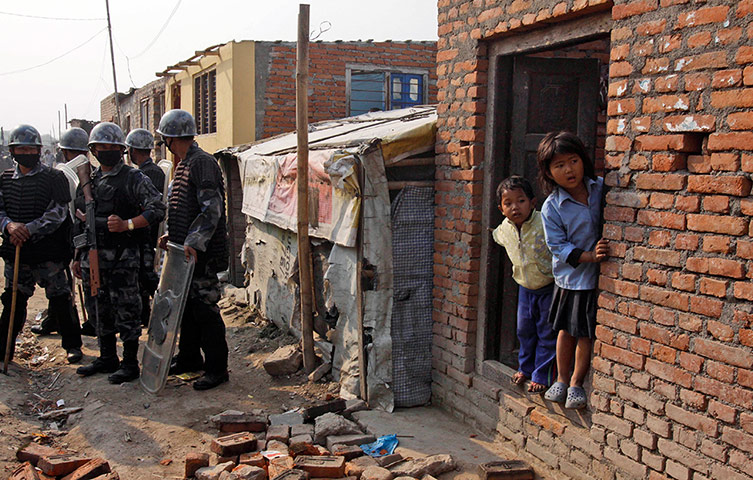Kathmandu eviction: young Nepalese children look at a bulldozer 