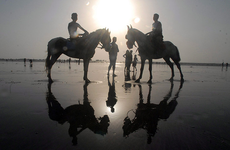 24 hours in pictures: A man rides on horseback near the water of Arabian Sea in Mumbai.