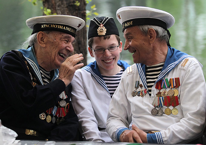 Victory Day in Russia: Russian WWII veterans and a young boy dressed in a vintage military uniform