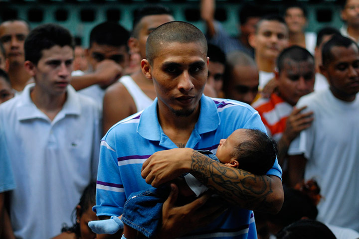 Longer View: An inmate and member of a gang holds his son at the jail in Quetzaltepeque
